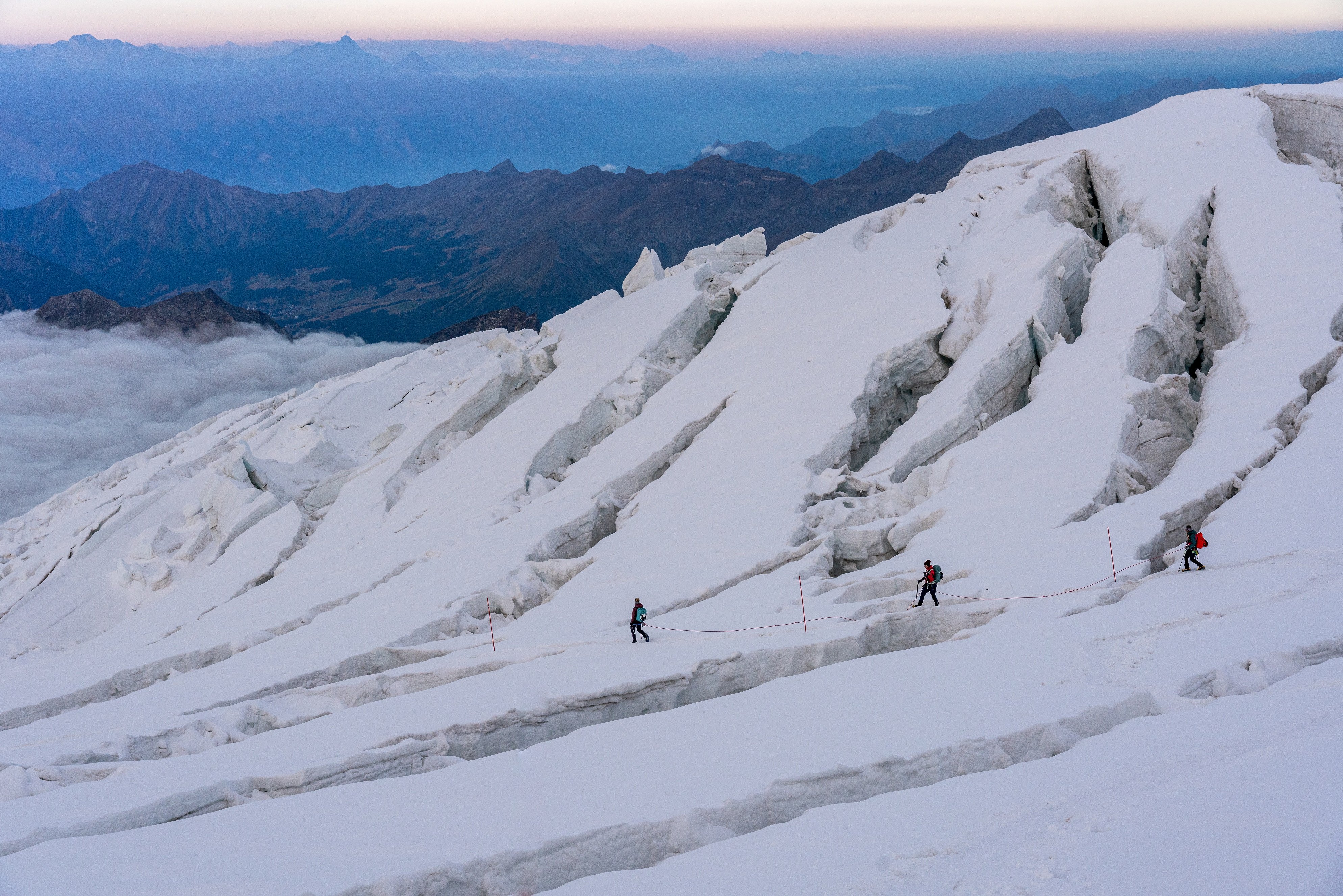 3 mountaineers navigate an crevasse field